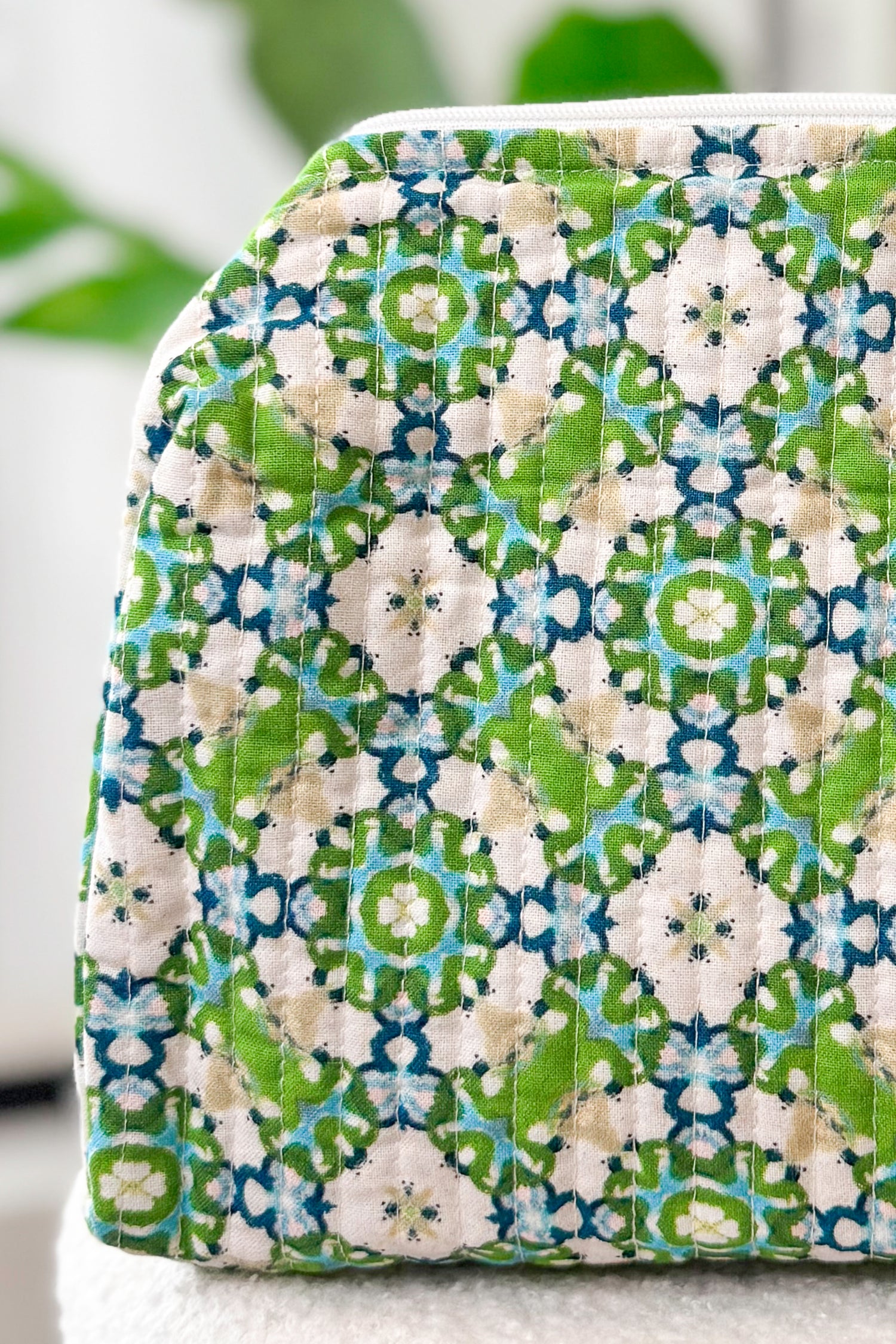 Fabric pouch with green and blue pattern on a white background