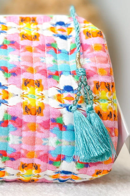 Colorful fabric pouch with a tassel on a neutral background