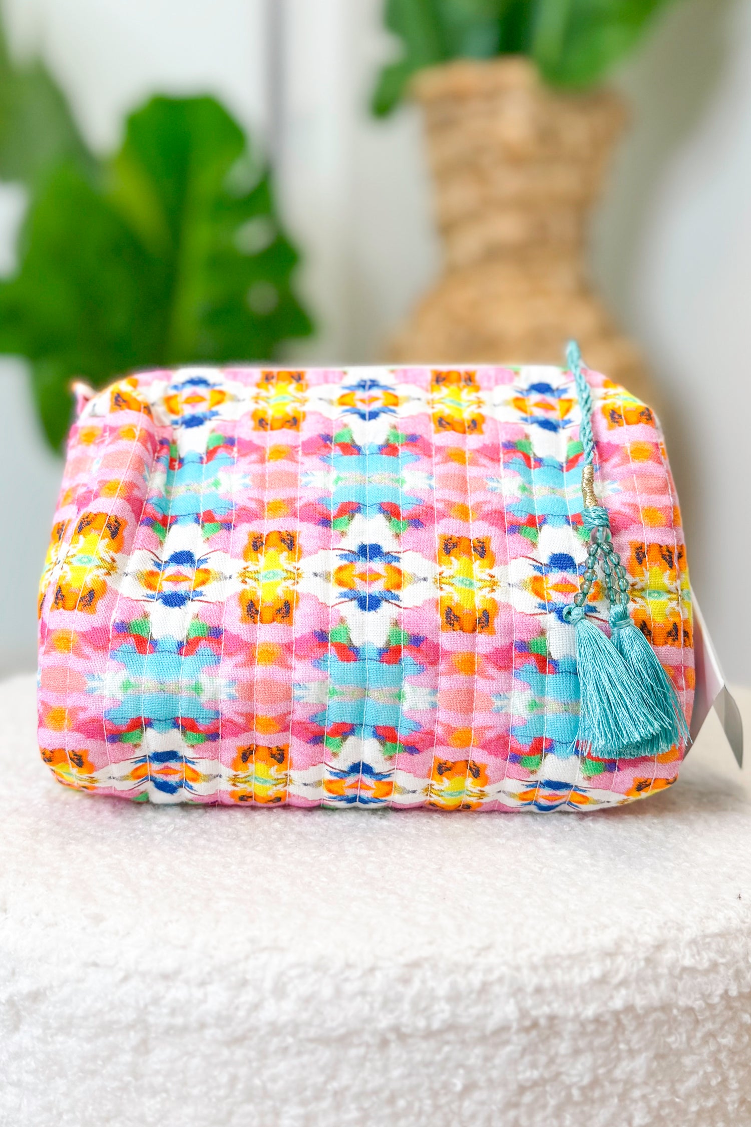 Colorful woven pouch with a tassel on a white surface with a blurred background