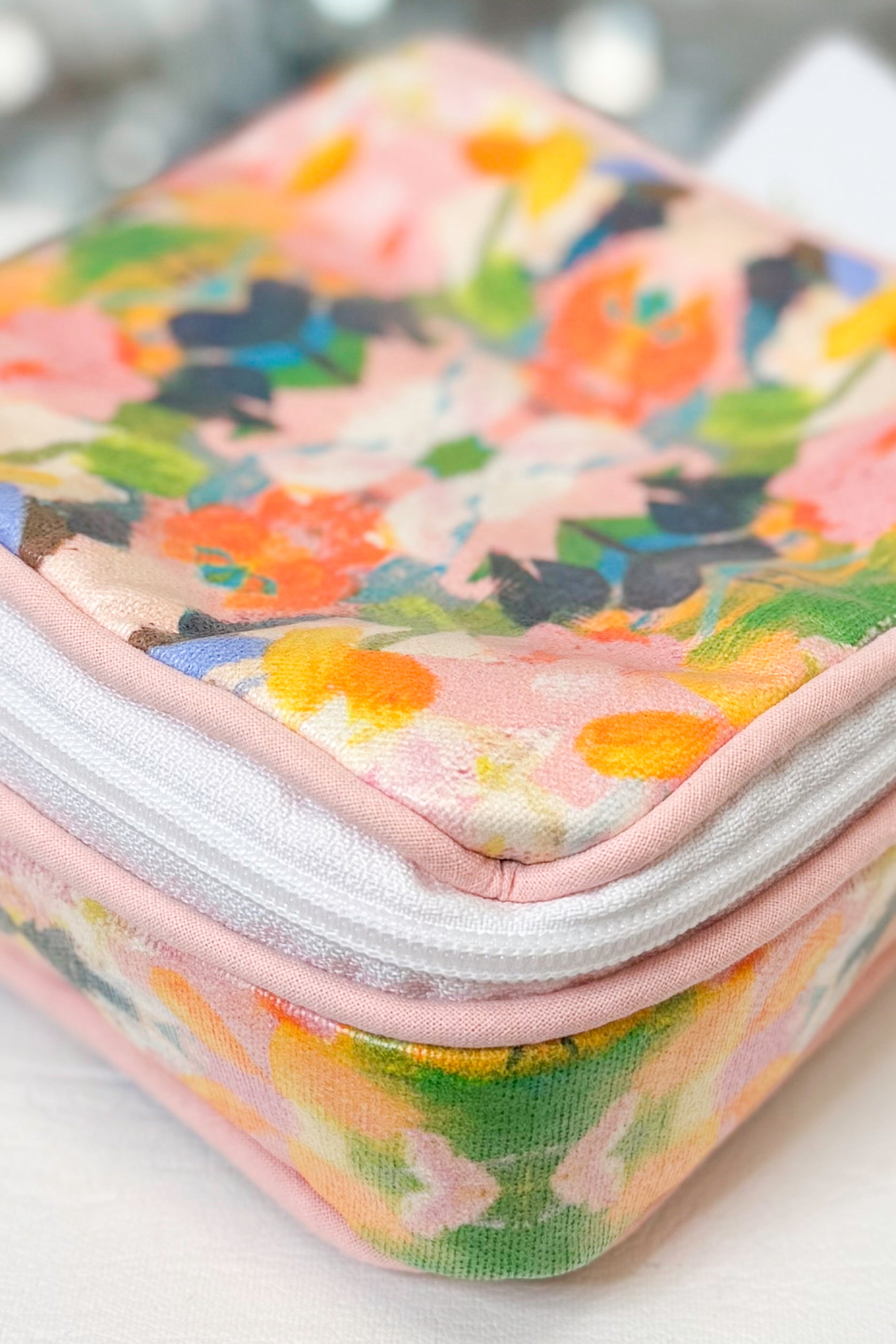 Floral-patterned makeup bag on a white surface
