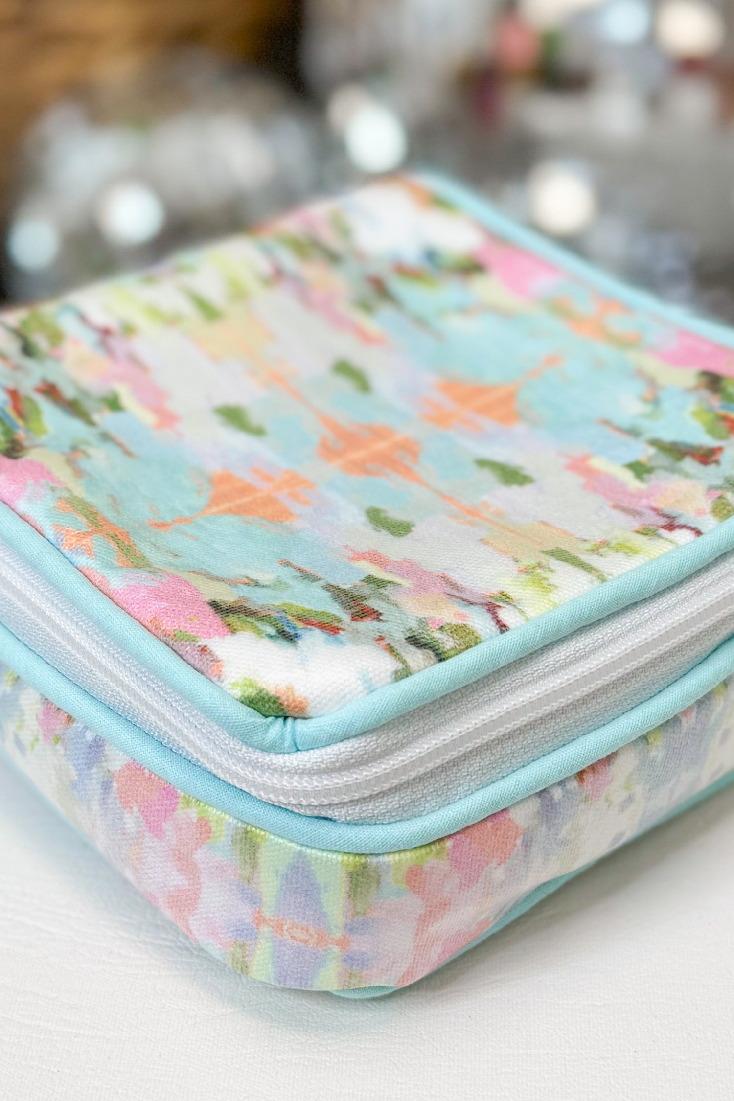 Floral-patterned makeup bag on a blurred background