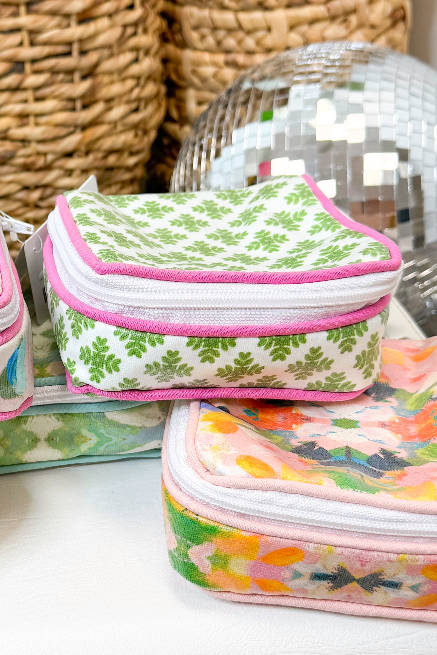 Two patterned fabric cases stacked on a surface with a wicker basket in the background.