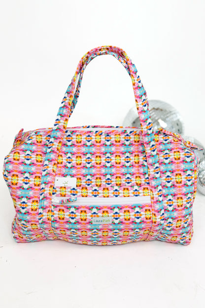 Multicolored patterned handbag with a visible brand label on a white background