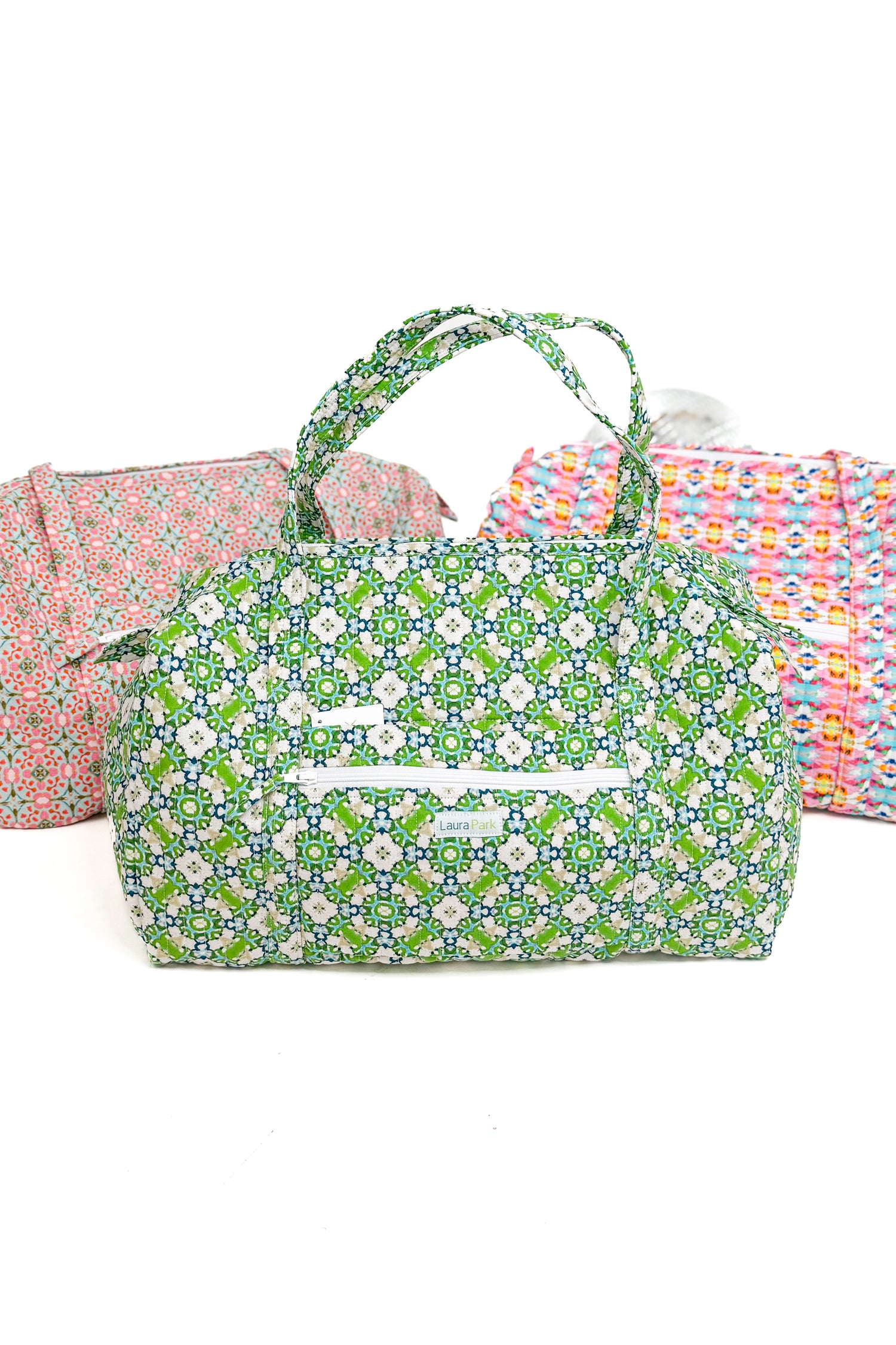 Floral patterned bag with two other bags in the background on a white background