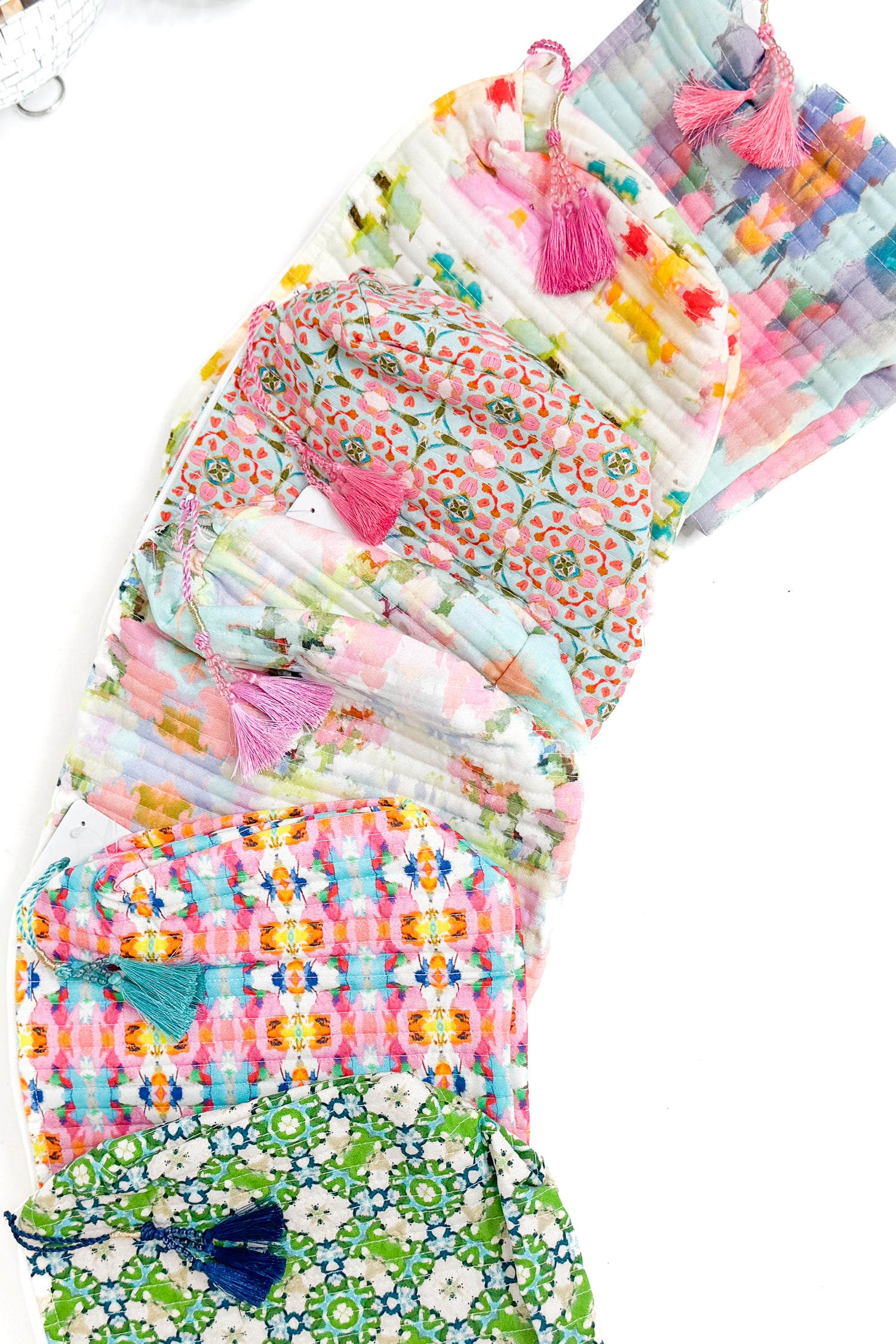 Stack of colorful fabric bags with tassels on a white background