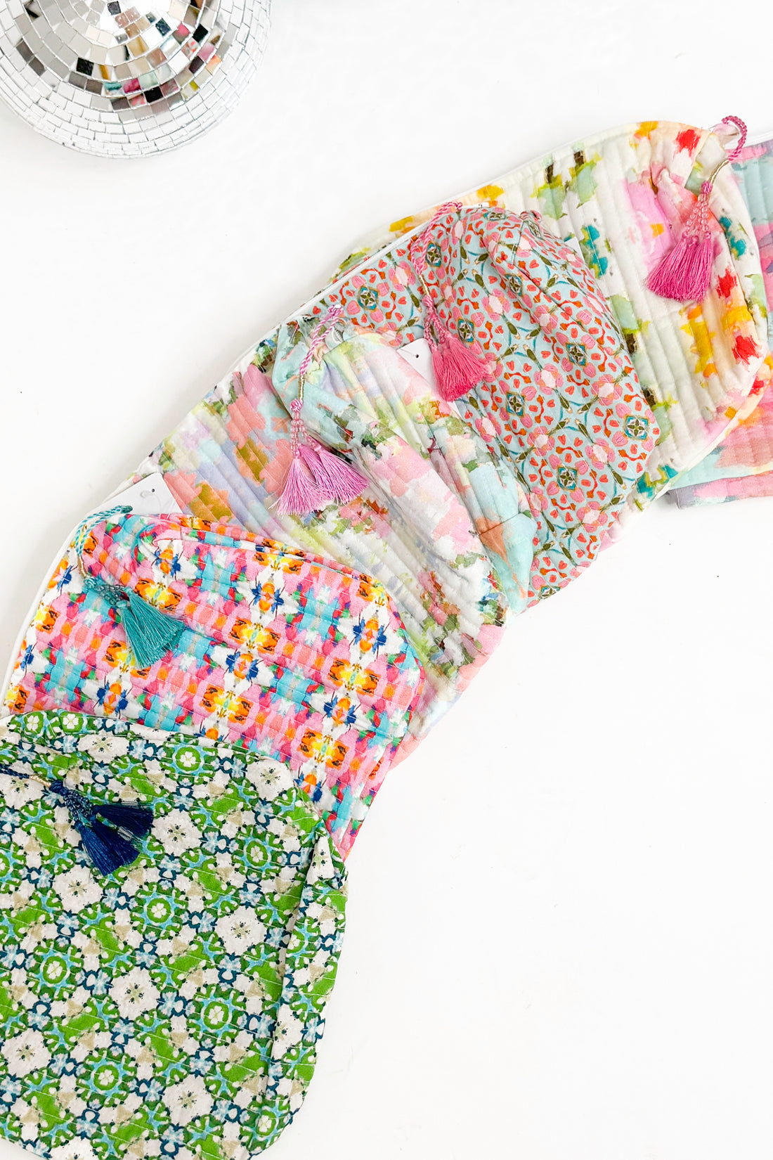 Collection of colorful fabric bags with tassels on a white background