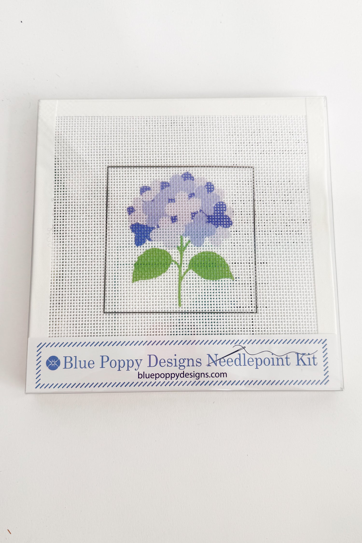 Needlepoint kit with a blue flower design on a white background
