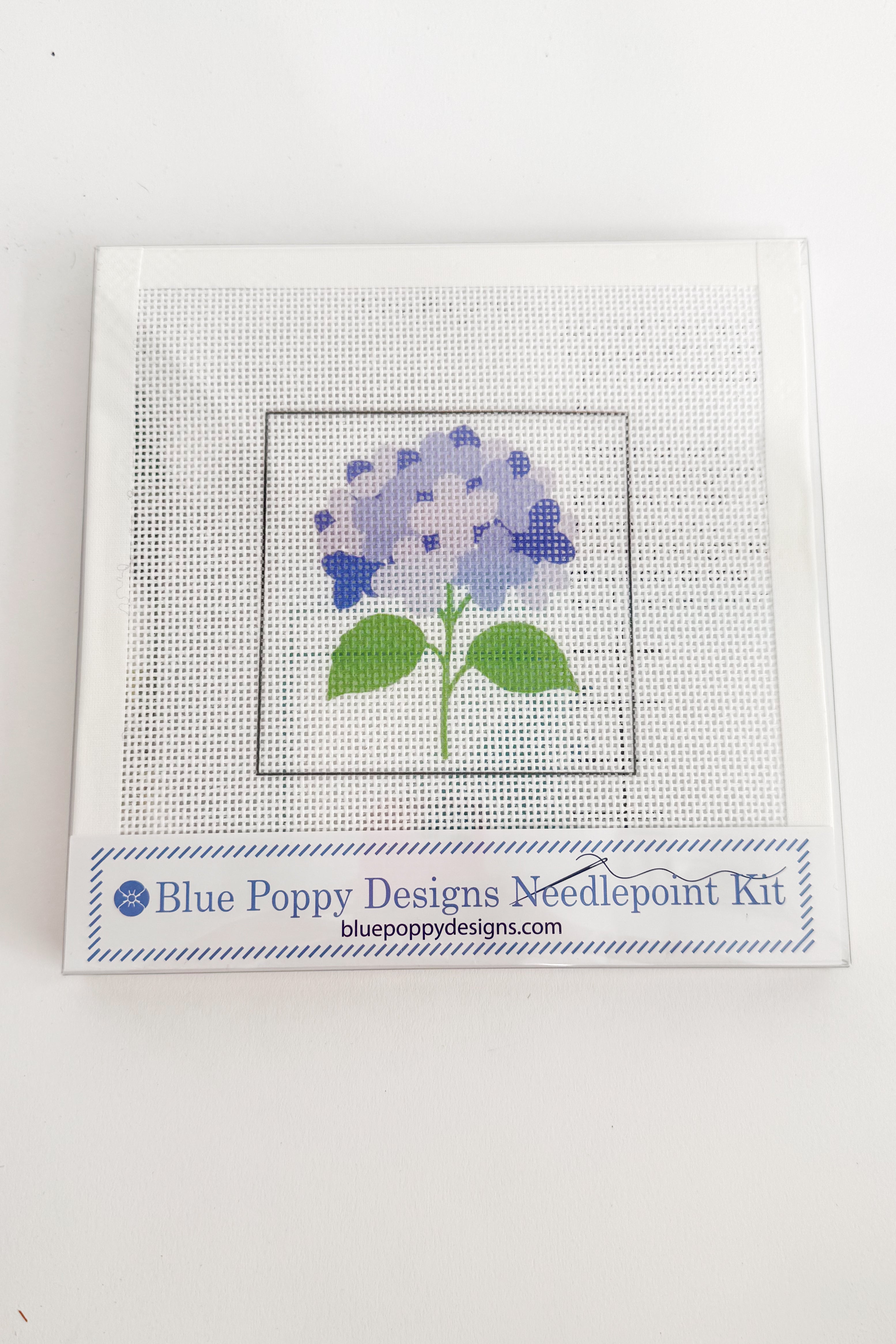 Needlepoint kit with a blue flower design on a white background