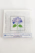 Needlepoint kit with a blue flower design on a white background