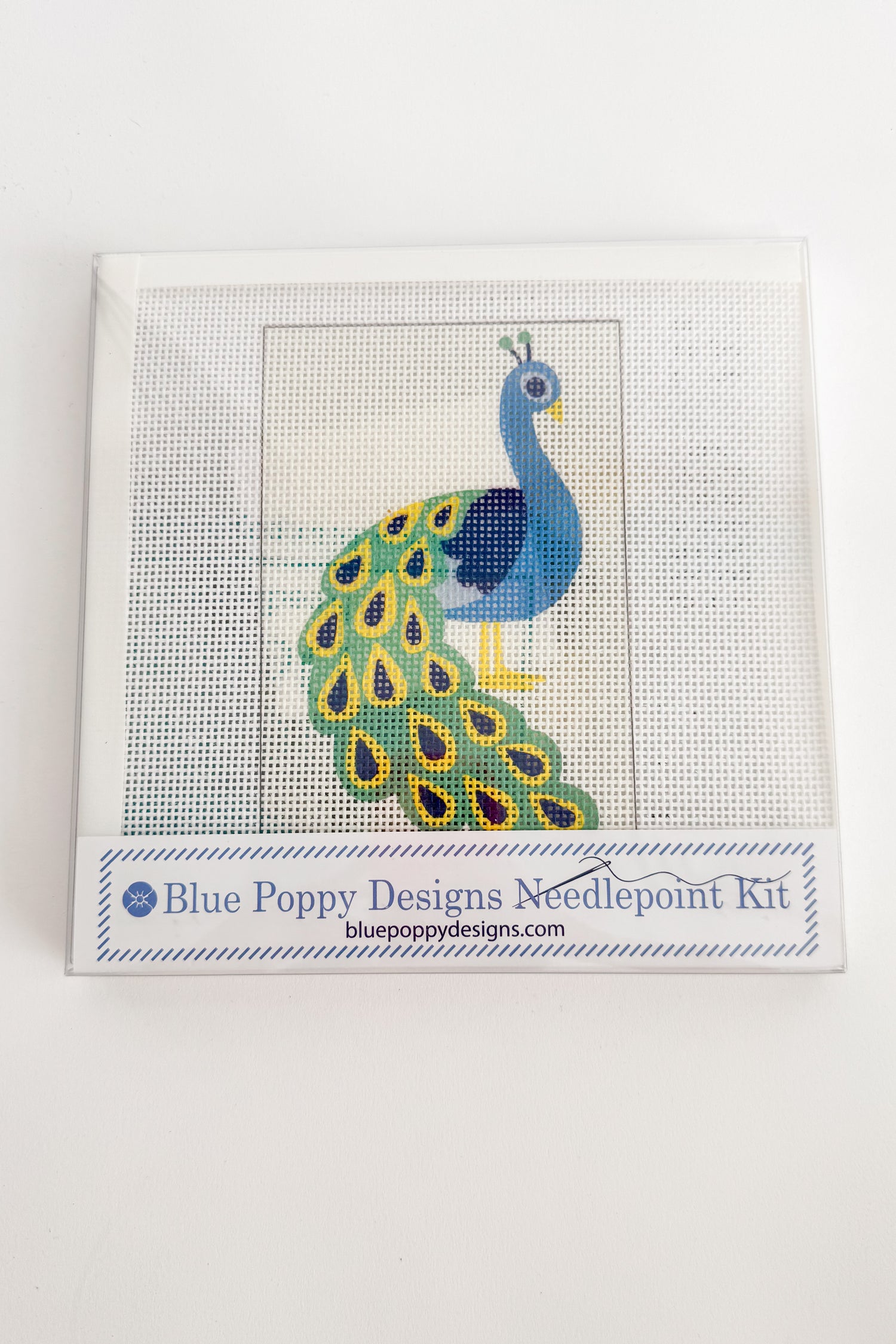 Cross-stitch kit with peacock design on a white background
