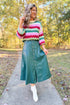 Front view of woman wearing Hunter Green Faux Leather Midi Skirt with striped sweater outside.