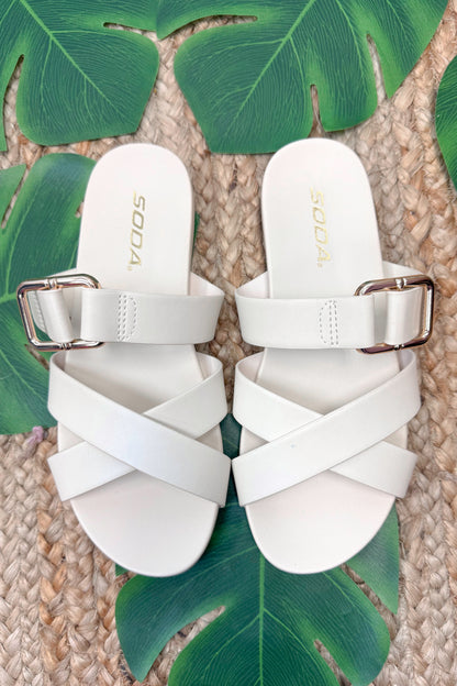 Terse- Bone Multi Strap Buckle Detail Sandal against beachy background.