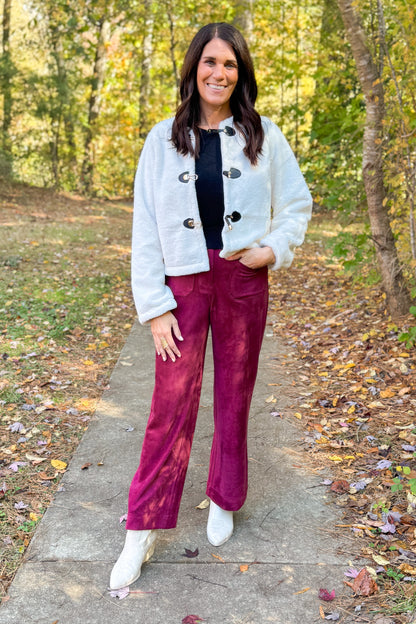 Front view of woman wearing Cream Faux Fur Toggle Button Jacket with Burgundy Suede Wide Leg Pants outside.