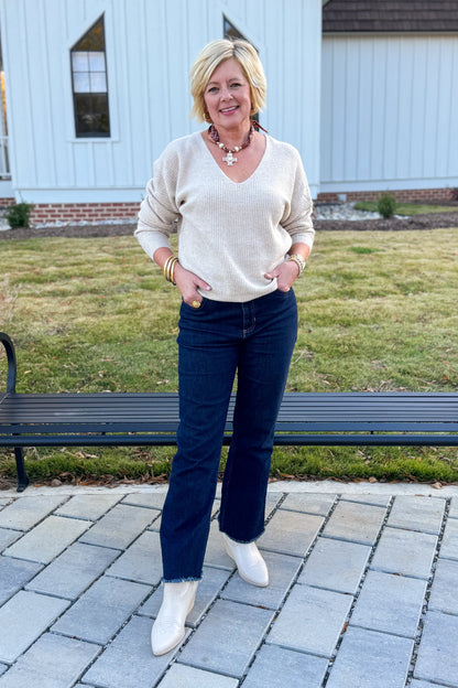 Woman standing outdoors on a patio with a white building in the background