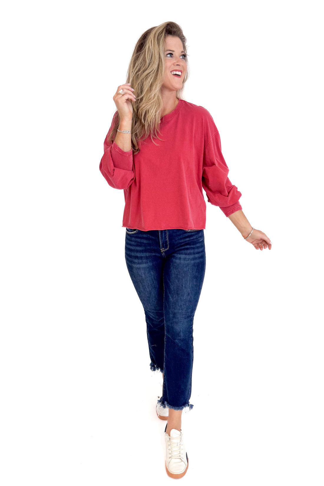 Woman wearing a red top and blue jeans on a white background