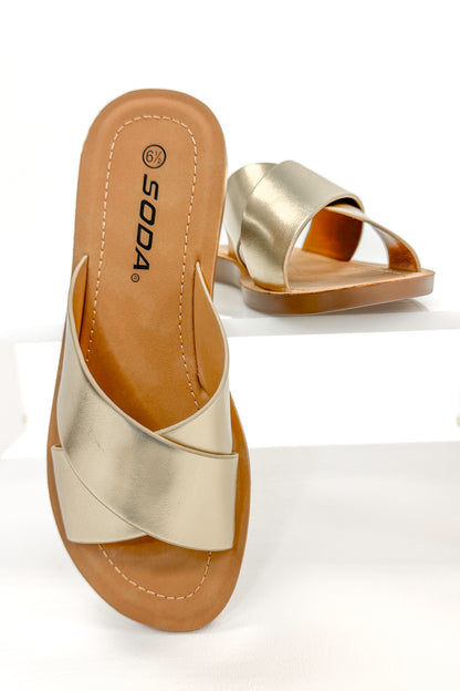 Reflect- Gold Cross Strap Sandals against white studio background