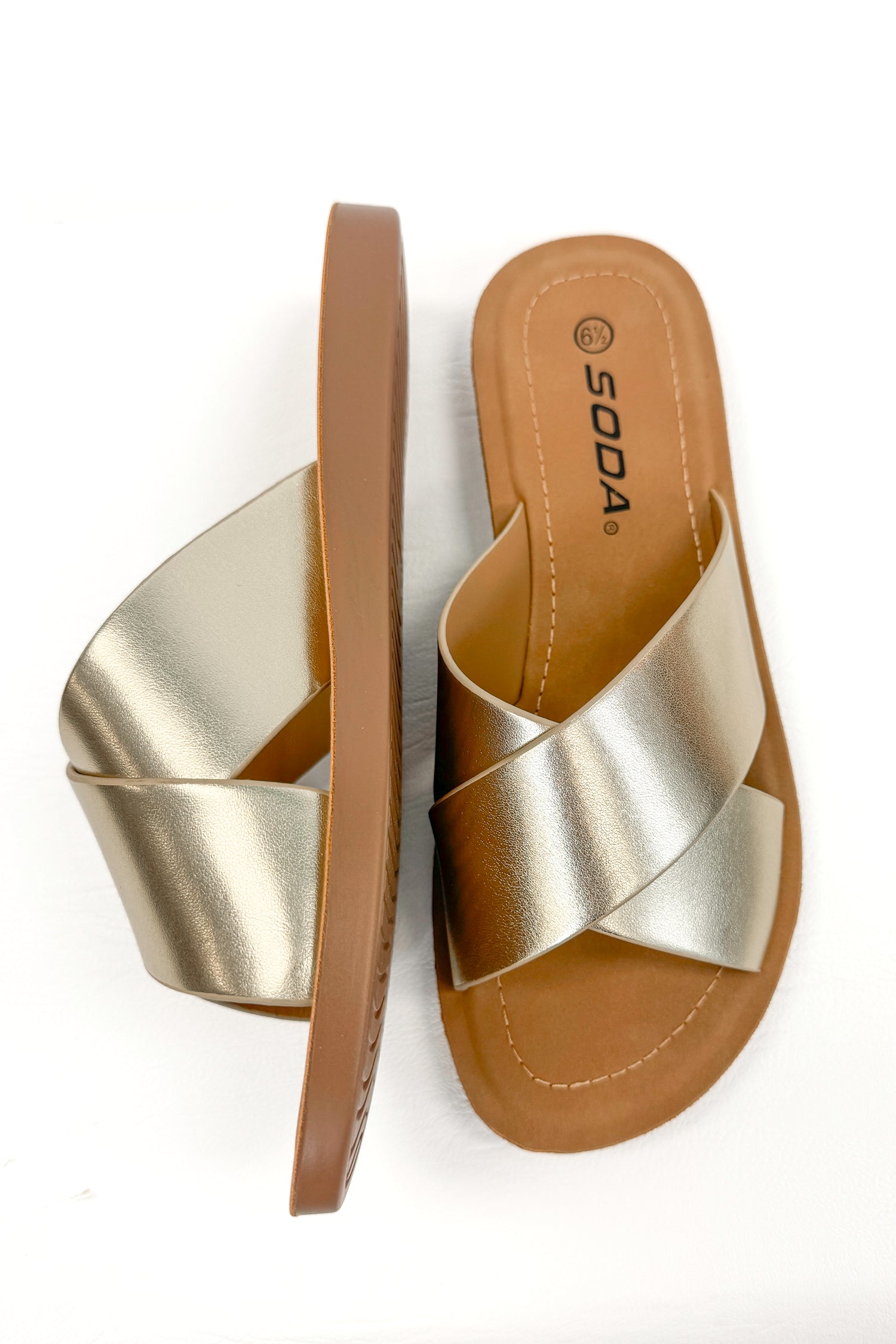 Reflect- Gold Cross Strap Sandals against white studio background