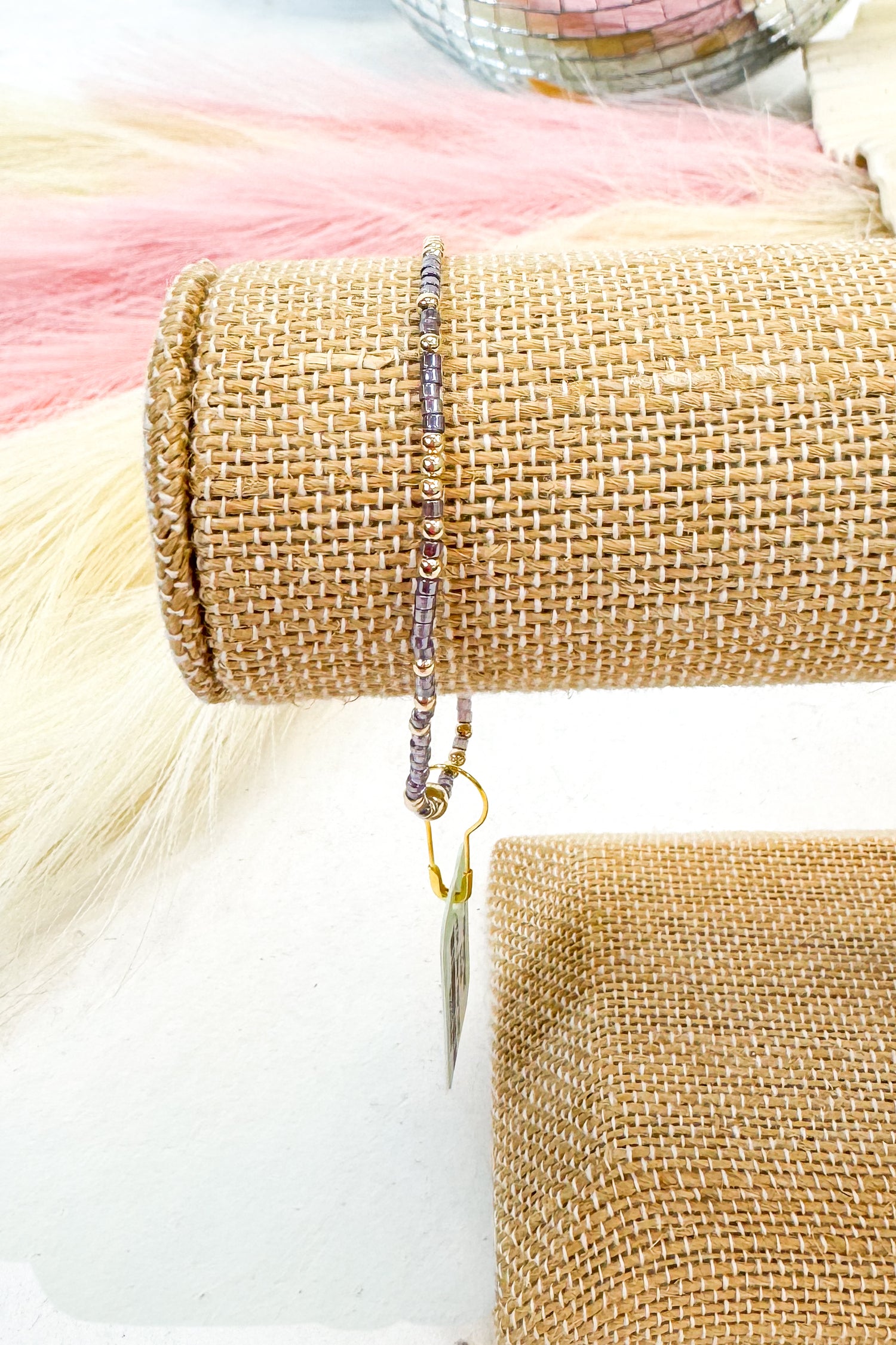 Close-up of a beaded bracelet on a textured fabric background