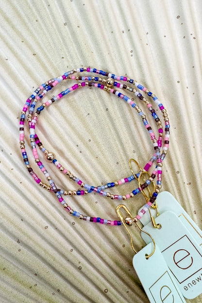 Colorful beaded bracelet on a textured beige background