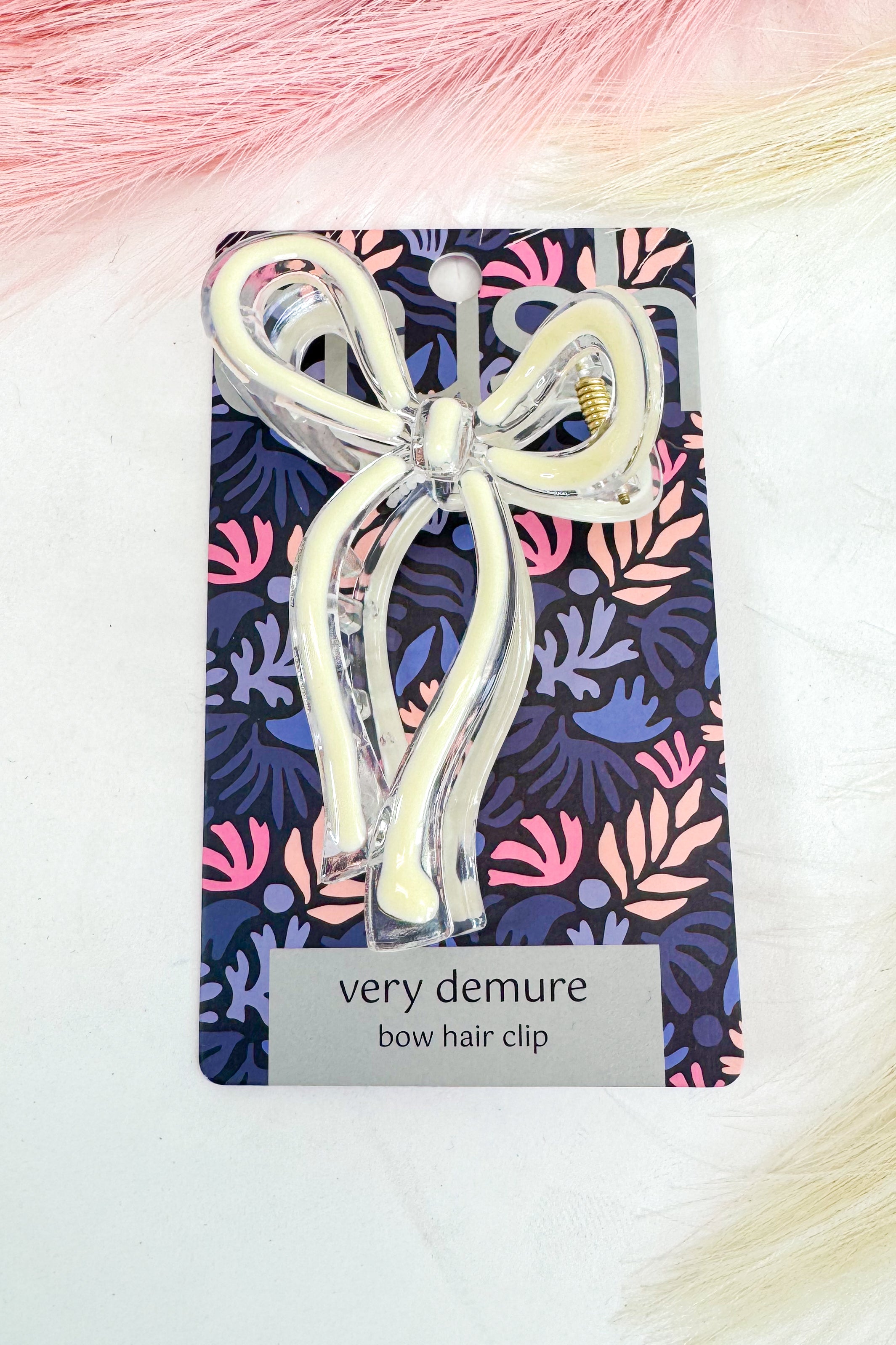 Bow hair clip on a colorful patterned card with &