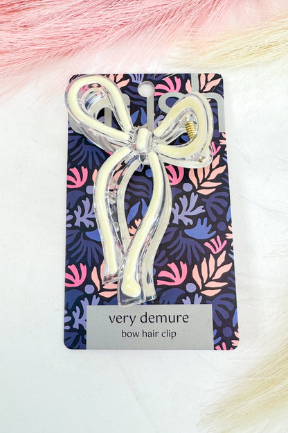 Bow hair clip on a colorful patterned card with &