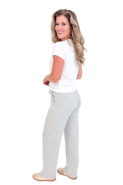 Side view of grey sweatpants and white top.
