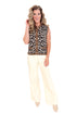 Woman wearing a leopard print vest and white pants on a white background
