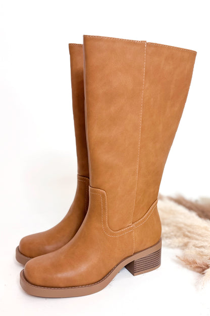 Pair of tan high boots on a white background