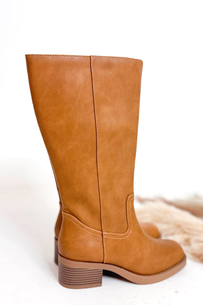 Pair of tan high boots on a white background
