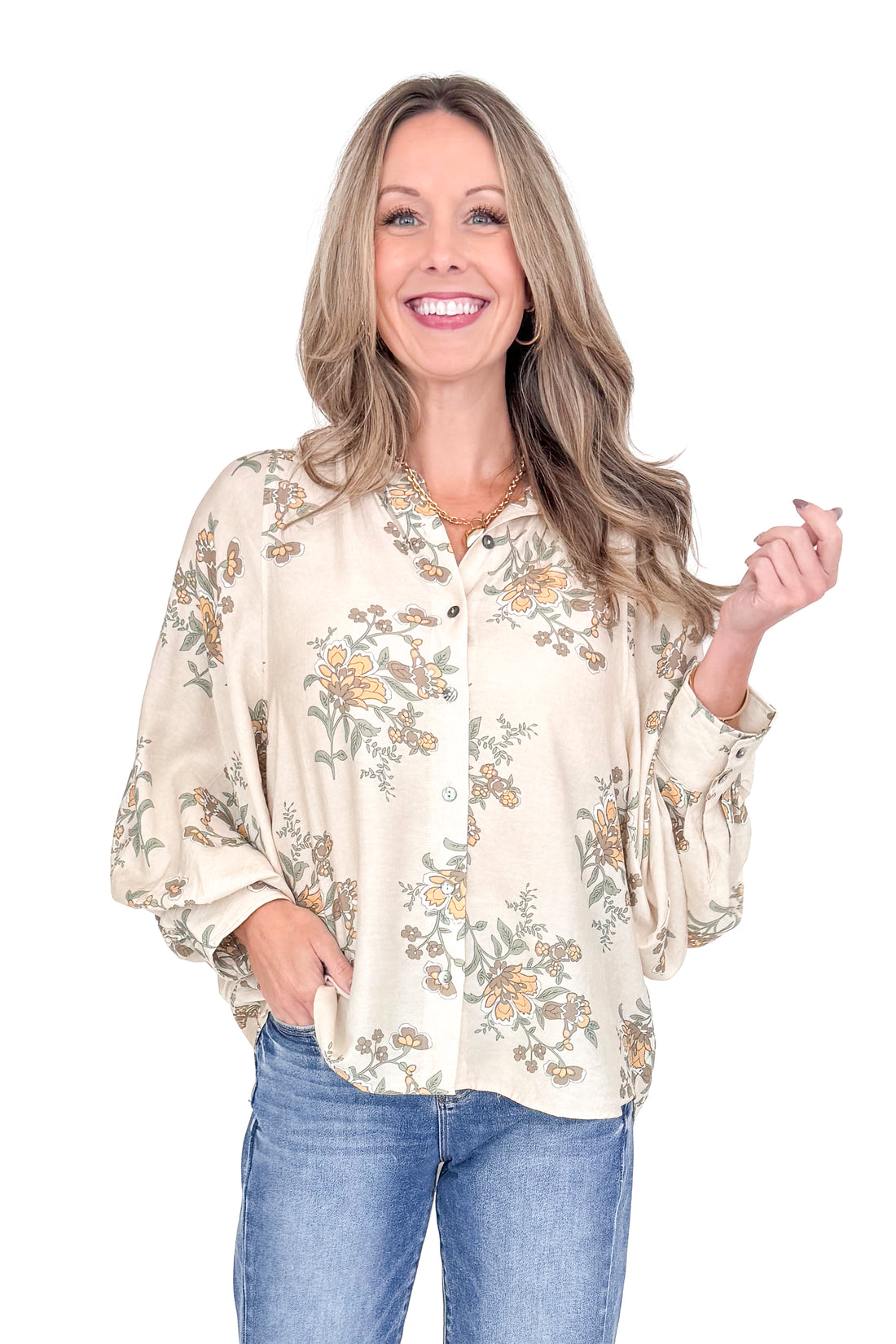 Woman wearing a floral blouse and jeans on a white background