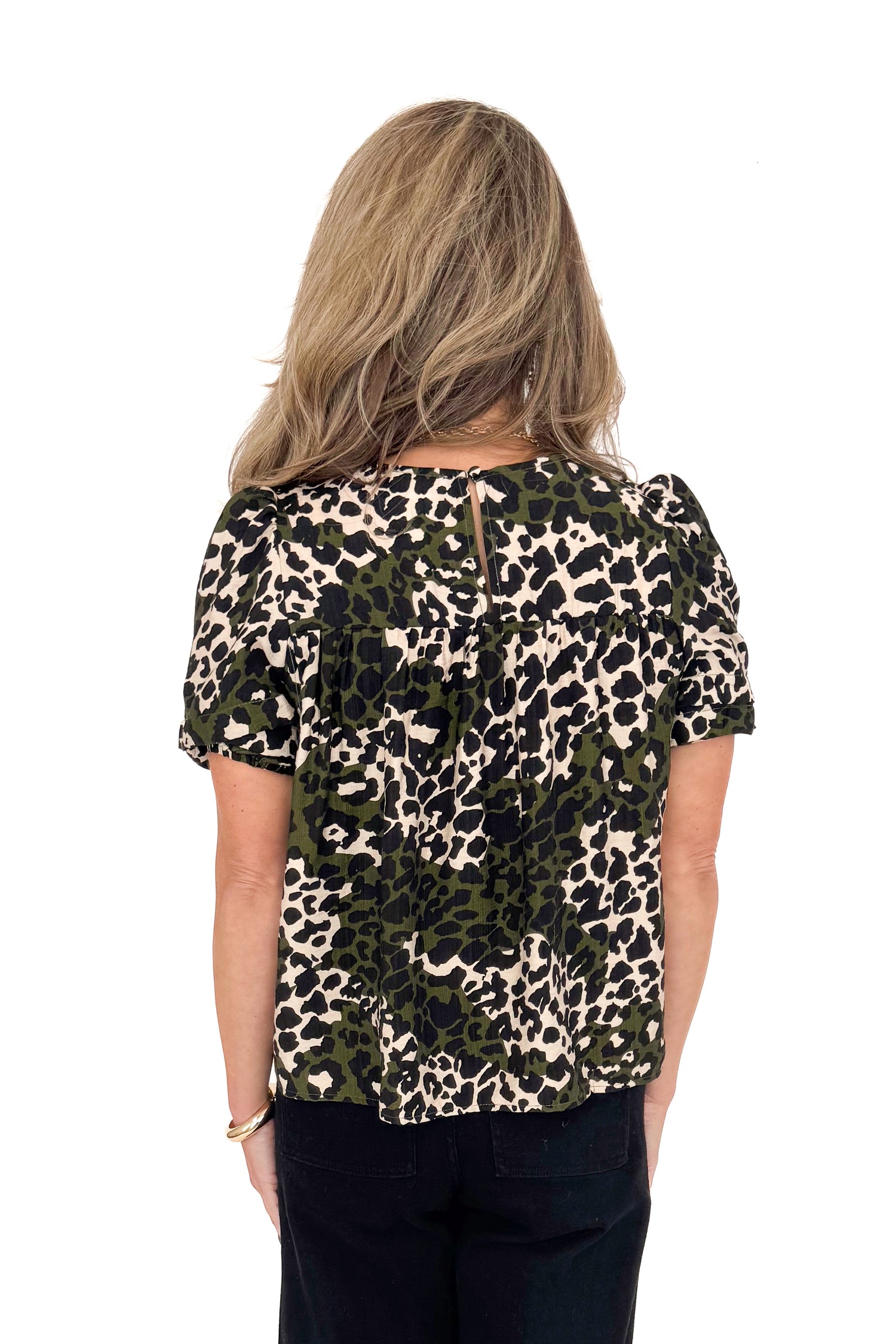 Woman wearing a leopard print top on a white background