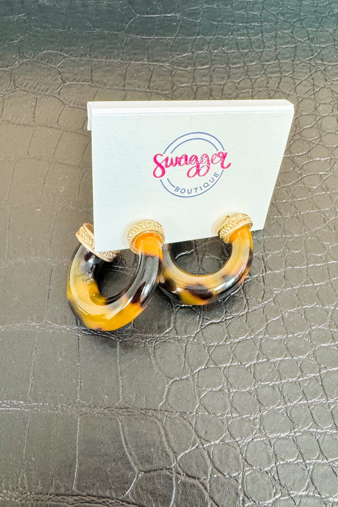 Pair of hoop earrings with tortoiseshell design on a Swagger Boutique card.