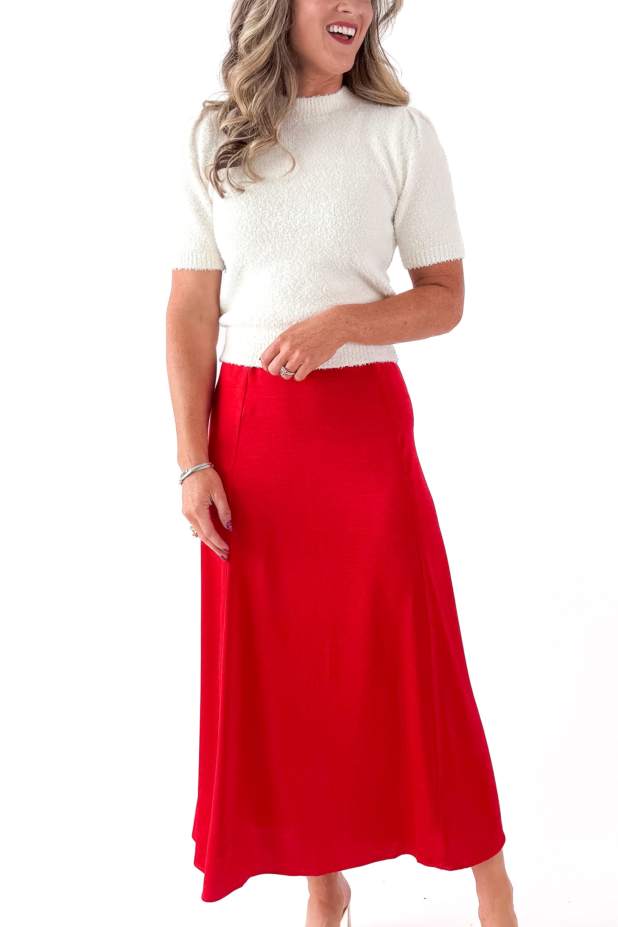 Side view of woman wearing cream top with Festive Red Northpointe Midi Skirt against white studio background.