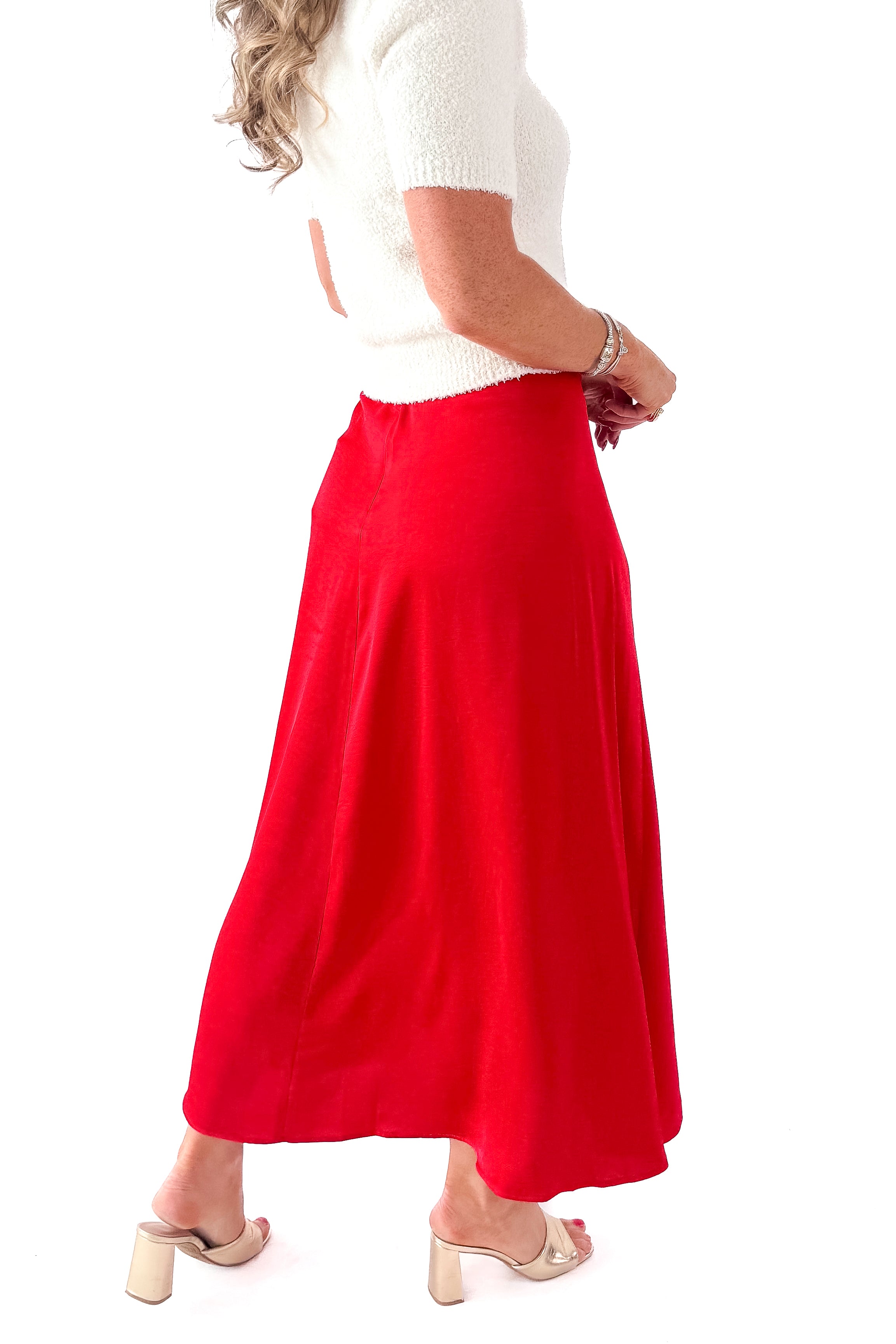 Side view of woman wearing cream top with Festive Red Northpointe Midi Skirt against white studio background.