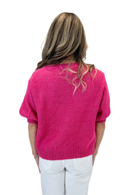 Back view of woman wearing Hot Pink Short Puff Sleeve Sweater with jeans against white studio background.