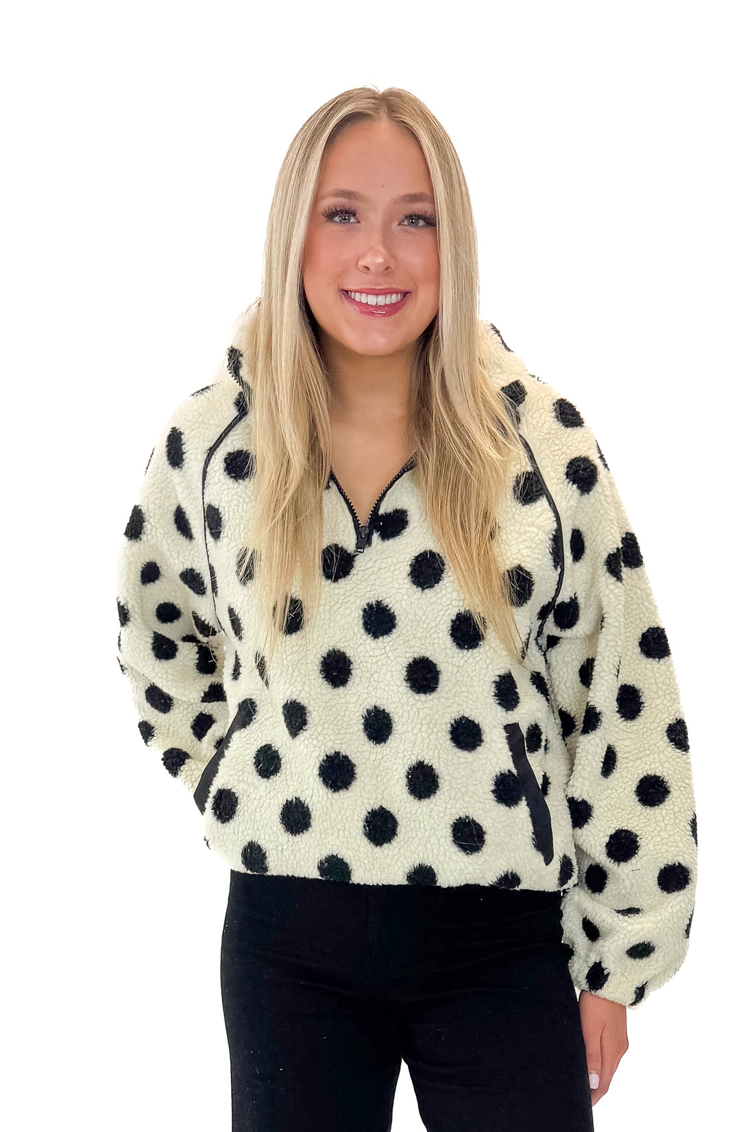 Front view of woman wearing Ivory &amp; Black Polka Dot Sherpa Half Zip Sweatshirt with jeans against white studio background.