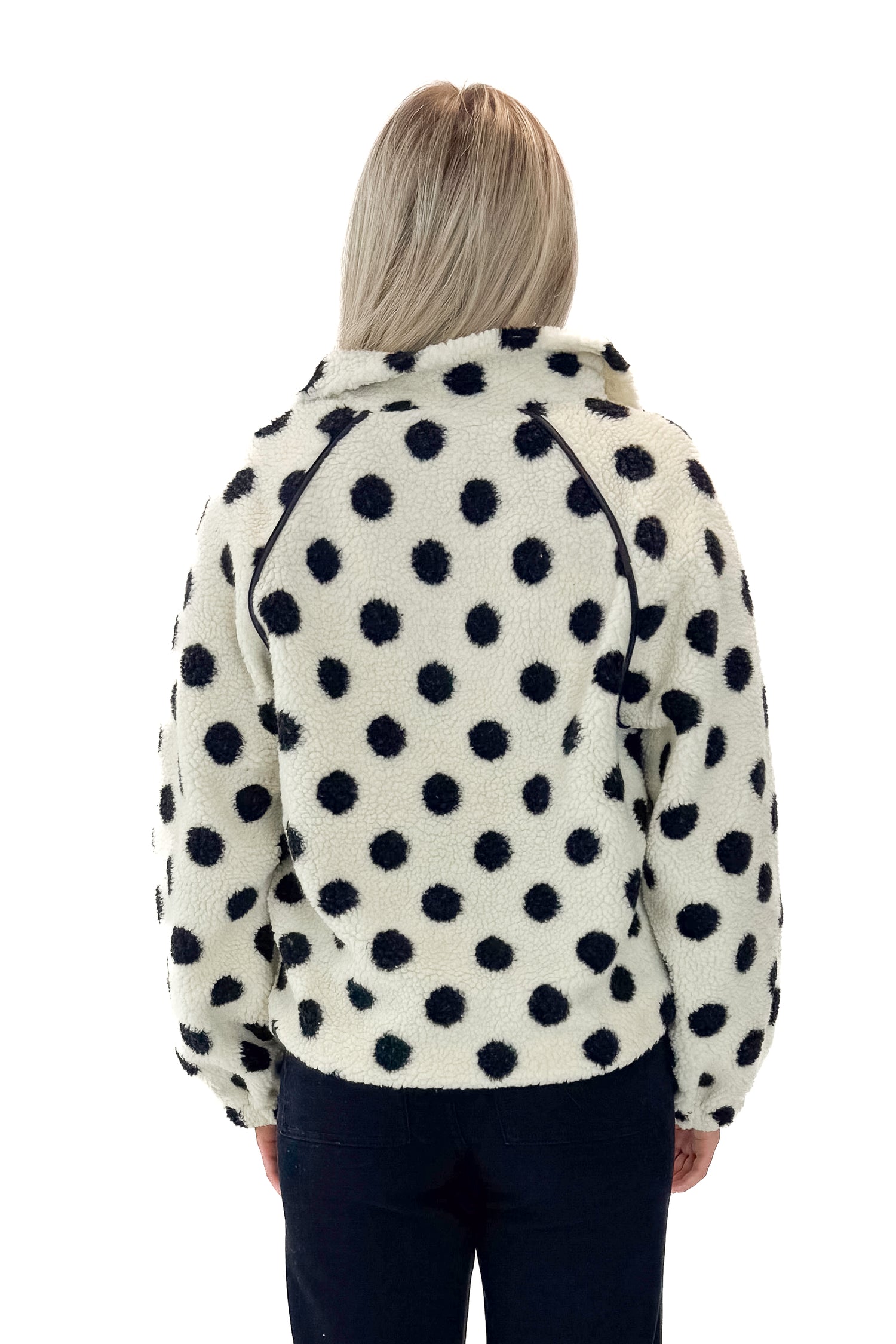 Back view of woman wearing Ivory &amp; Black Polka Dot Sherpa Half Zip Sweatshirt with jeans against white studio background.
