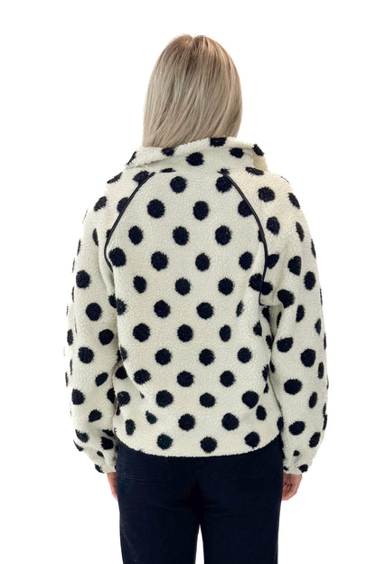 Back view of woman wearing Ivory &amp; Black Polka Dot Sherpa Half Zip Sweatshirt with jeans against white studio background.