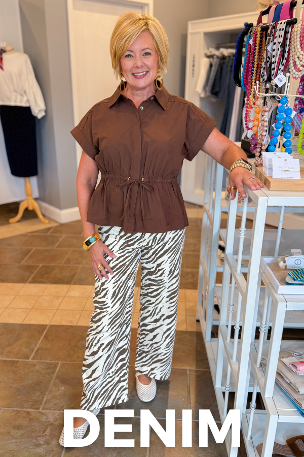 front view of woman wearing brown cinched top paired with zebra jeans. 