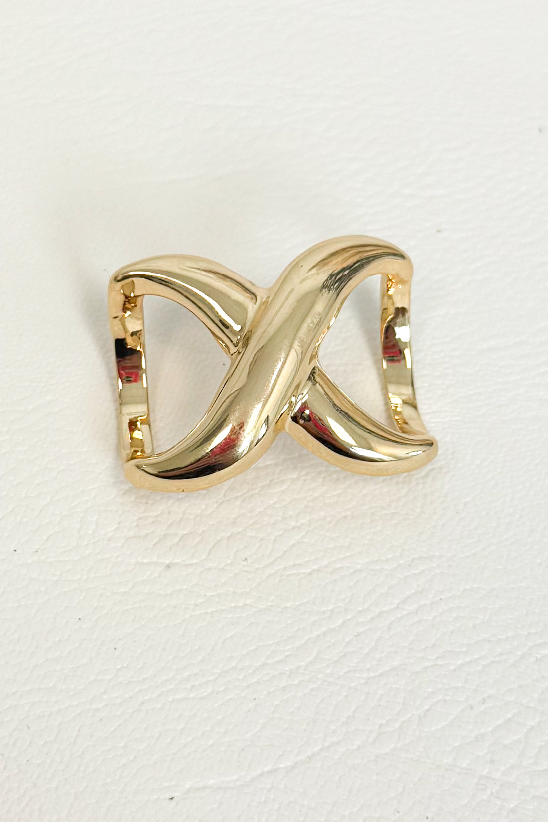 Gold-tone double-loop scarf ring enhancer with an intertwined design on a white studio background