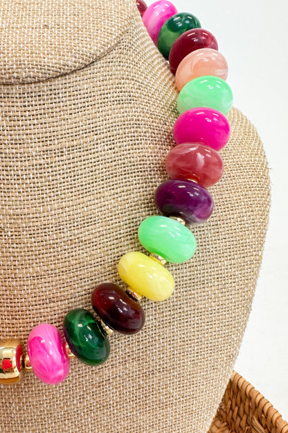 Colorful beaded necklace on a mannequin bust with a neutral background