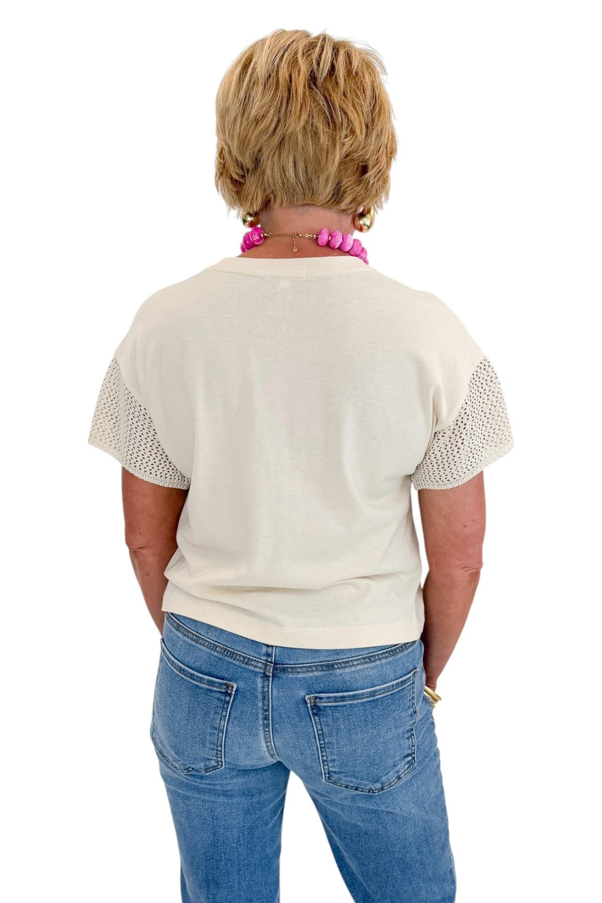 Back view of woman wearing Swagger Boutique’s Island Coconut Banyan Top by Z Supply with jeans against white studio background.