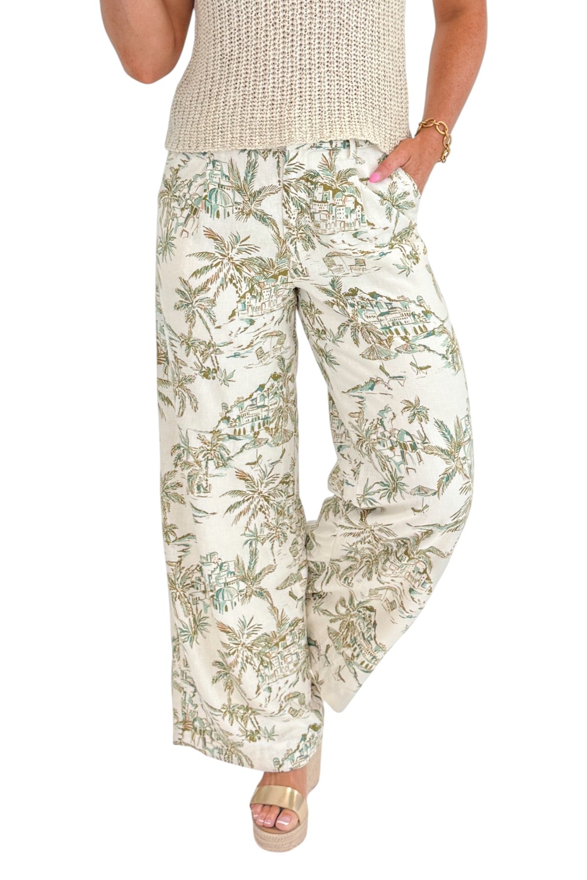 Front detail view of woman wearing Swagger Boutique’s Island Coconut Overlook Tiki Tide Linen Pants with Beige V-Neck Knitted Tank by Skies Are Blue against white studio background.