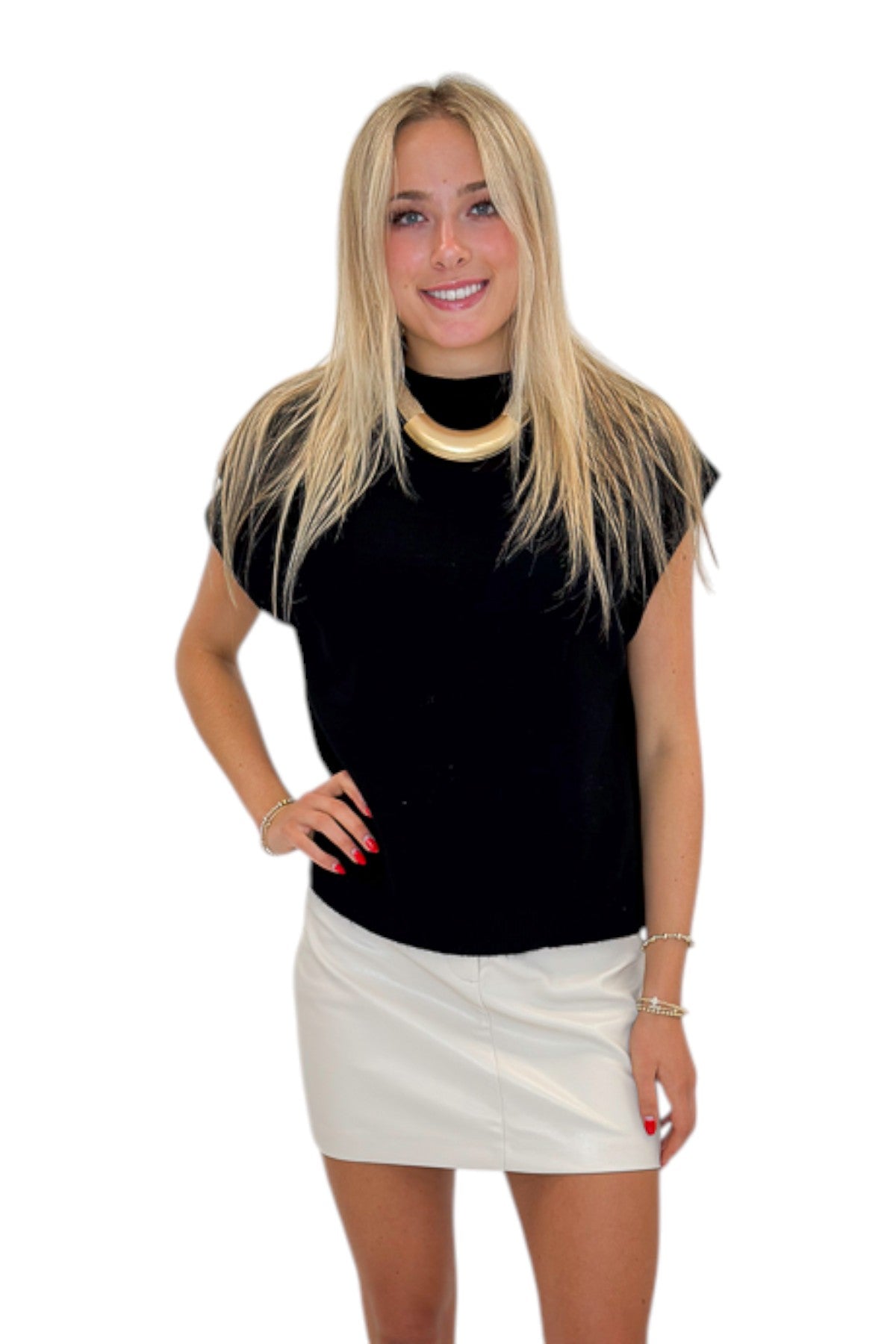 Front view of woman wearing Swagger Boutique’s Ivory Faux Leather Mini Skirt with black sweater against white studio background.