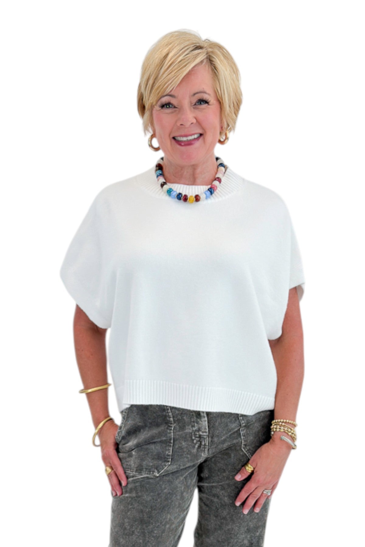 Front view of woman wearing Swagger Boutique’s Ivory Light Weight Short Sleeve Sweater with jeans against white studio background.