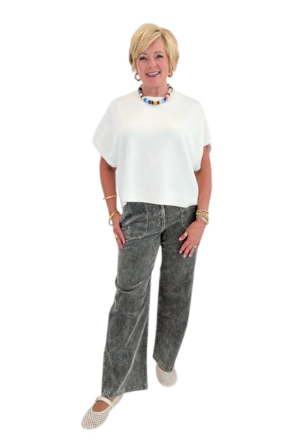 Front view of woman wearing Swagger Boutique’s Ivory Light Weight Short Sleeve Sweater with Washed Stone Corduroy Pants against white studio background.