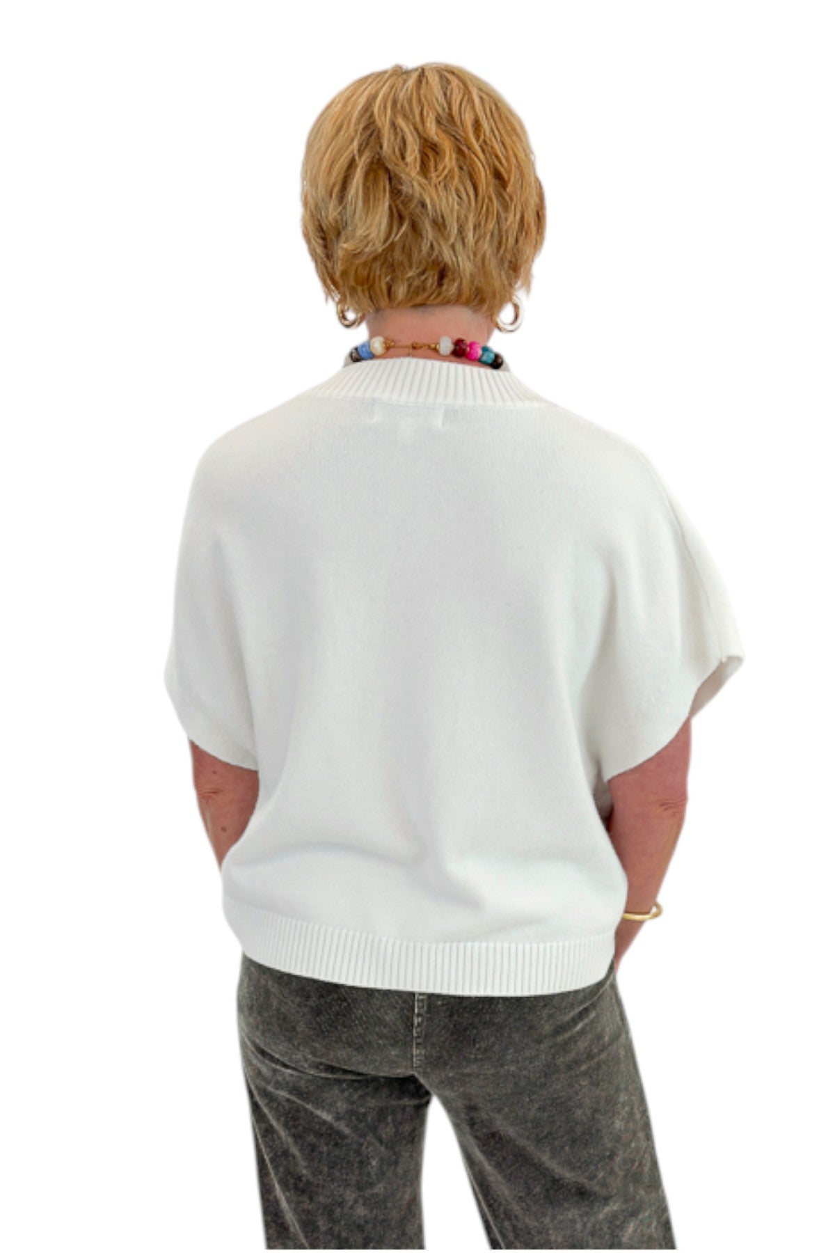 Back view of woman wearing Swagger Boutique’s Ivory Light Weight Short Sleeve Sweater with jeans against white studio background.