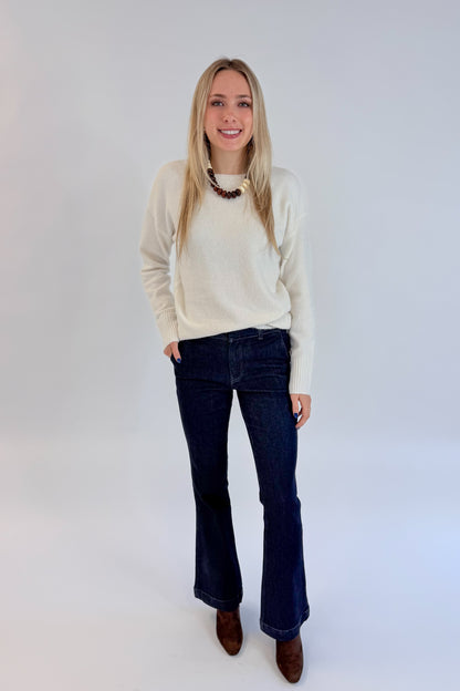Front view of woman wearing Swagger Boutique’s Ivory Ribbed Hem Sweater with jeans against white studio background.