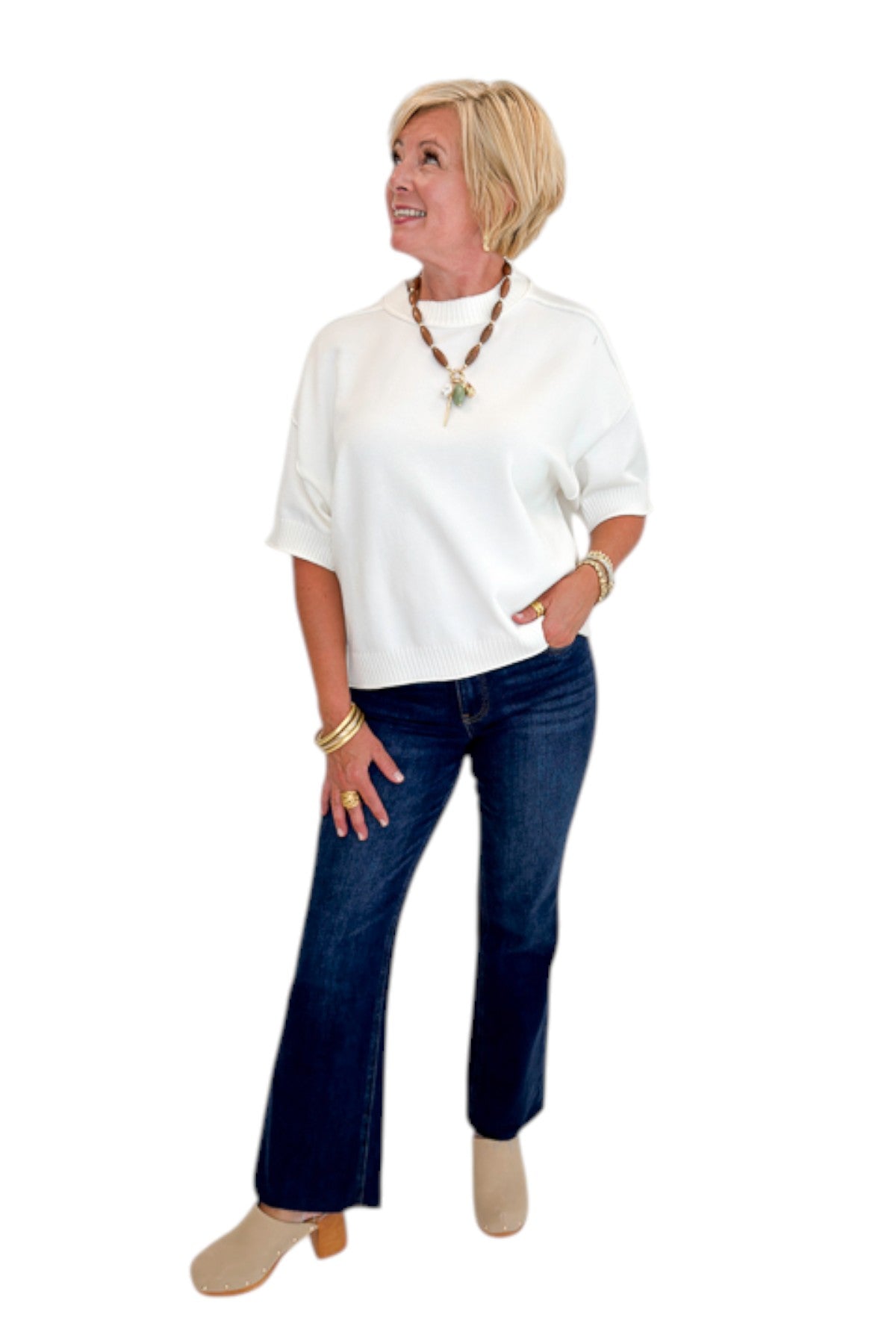 Front view of woman wearing Swagger Boutique’s Ivory Short Sleeve Sweater with jeans against white studio background.