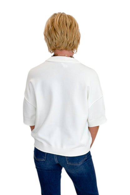 Back view of woman wearing Swagger Boutique’s Ivory Short Sleeve Sweater with jeans against white studio background.